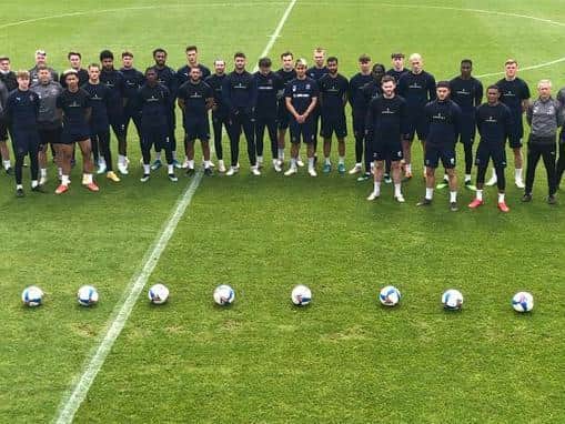 Blackpool players and staff stand behind nine footballs in silent tribute to Jordan Banks