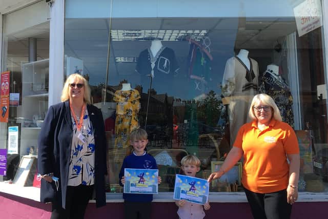 Teddy and Barnaby Couch receiving their certificates from Home-Start chief executive Pat Naylor (left) and shop manager Sue Uttley.