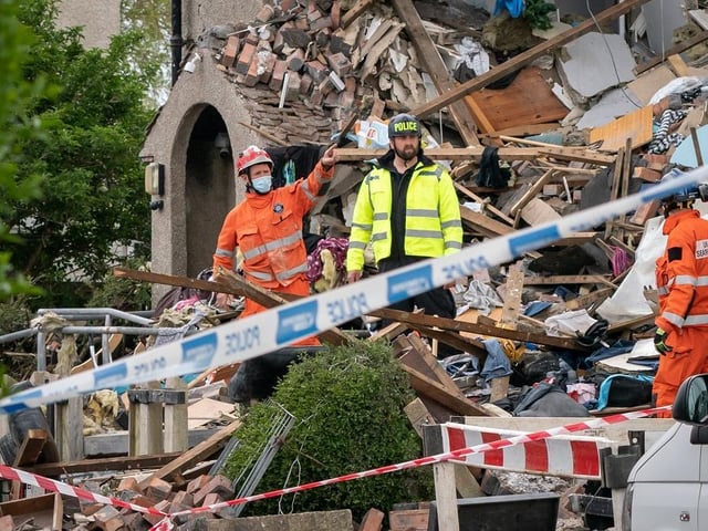 Emergency workers at the scene of a suspected gas explosion, in which a young child was killed and two people were seriously injured
