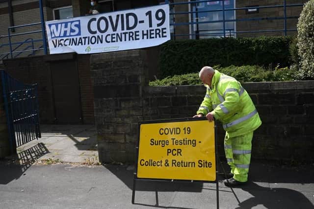 A worker sets outs a sign for a Covid-19 PCR Surge testing site, and vaccination centre, at the United Reformed Church in Blackburn