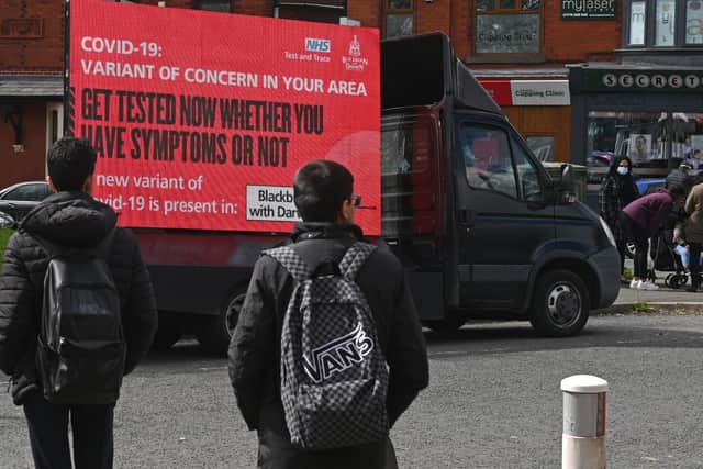 Information advising people to get tested due to the prevalence of a coronavirus covid-19 variant is displayed on a screen attached to a vehicle on the streets of Blackburn.