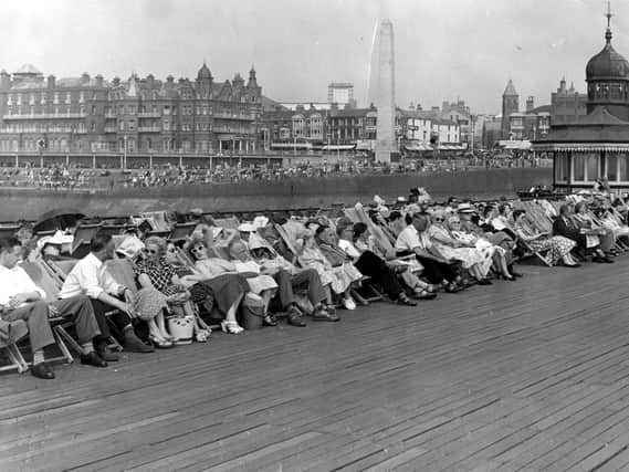 Holidaymakers relaxing in deckchairs on North Pier in 1955