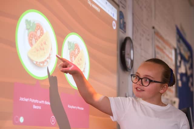 Pupil Tilly Warner demonstrates how to use the interactive whiteboard to make school lunch choices. Picture: Daniel Martino/JPI Media