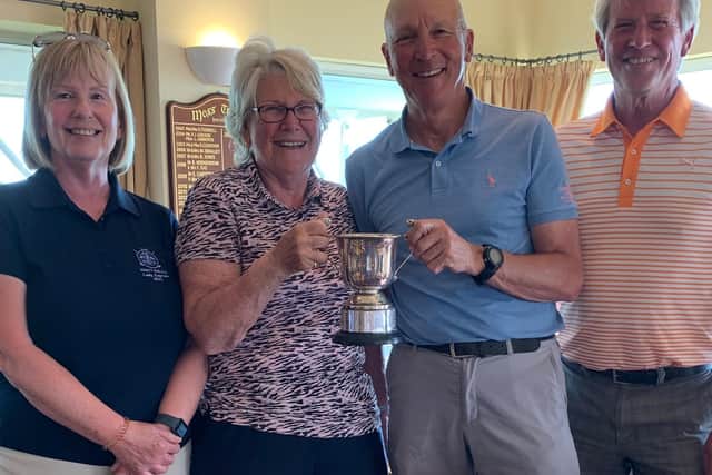 Knott End Golf Club President Linda Smith and her playing partner Mark Preston with the Moss Trophy, presented by captains John Wright and Felicity Lawson