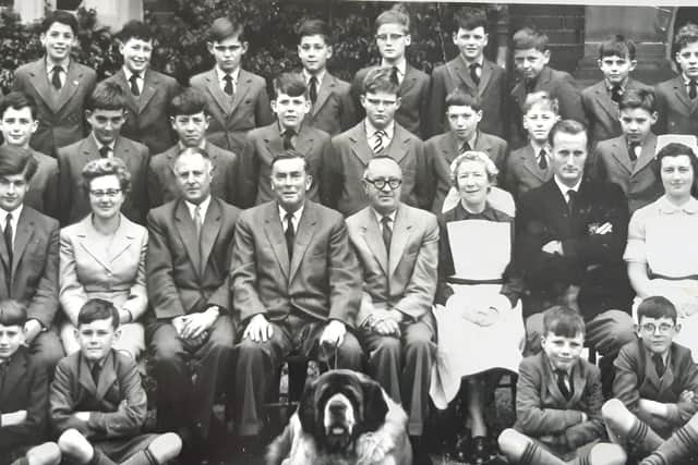 Headteacher Eric Heard is pictured behind the dog with his hands on his knees.To his right is Mr Doidge, Mrs Kenyon and Mr Battersby. To his left is Mr Taylor (wearing glasses), Matron, Paddy Molloy, the school Sister and Mr Garrett