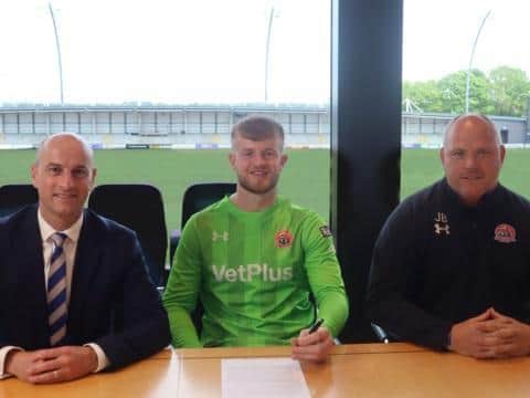 Goalkeeper Bobby Jones signs for AFC Fylde, flanked by manager Jim Bentley (right) and chief executive Joney Castle.