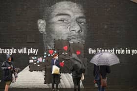 People start to cover the racist graffiti on Marcus Rashford's mural with messages of love in Withington