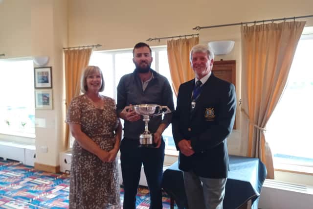 Knott End’s Luke Walker receives the Wyreside Trophy from club captains John Wright and Felicity Lawson