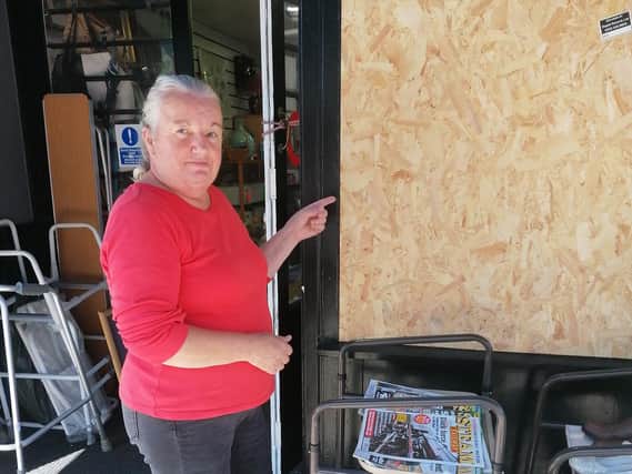 Belinda Armstrong with the boarded-up window at the Ist Scouts shop in Fleetwood