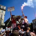 A protestor holds a placard reading "We are not QR codes" during a demonstration against the new coronavirus safety measures including a compulsory health pass called for by the French government, in Marseille on July 17 (Photo by CLEMENT MAHOUDEAU/AFP via Getty Images)