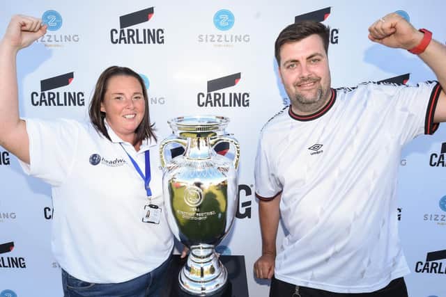 Newton Arms landlord Aaron Johnson with Samantha Ashcroft from Headway and a replica of the Euro trophy at the pub's Carling Fan Zone