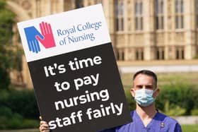 A Nurse with a placard outside the Royal College of Nursingin Victoria Tower Gardens, London