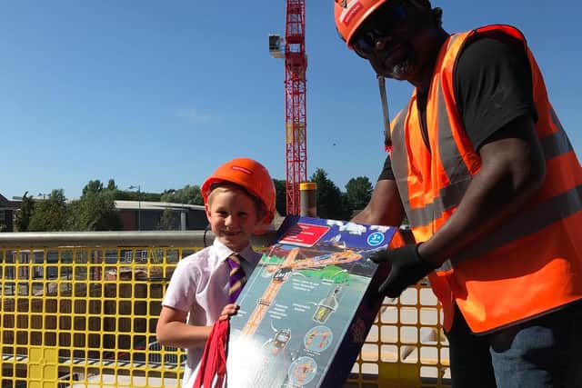 Findlay Clark is presented with gifts by crane driver Manny Marfo on his visit to the Adington site