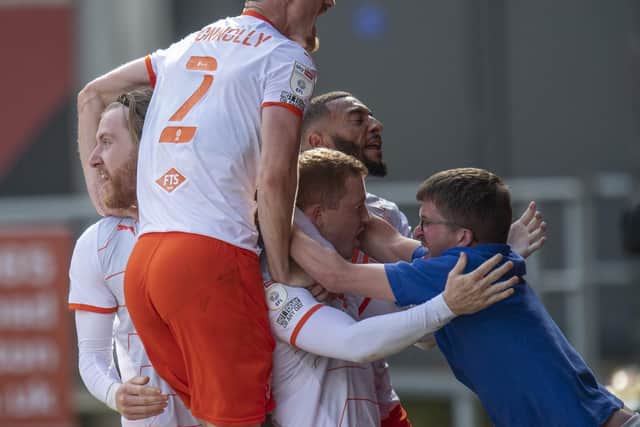 Shayne Lavery is mobbed by his teammates and supporters after his dramatic last-gasp equaliser