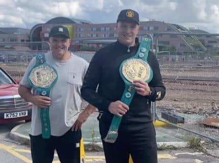 Tyson Fury with dad John and the two belts he will be donating as part of the fundraiser. Photo: Instagram @gypsyking101