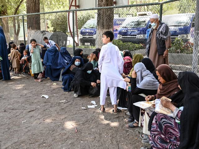 Internally displaced Afghan families, who fled from Kunduz and Takhar province due to battles between Taliban and Afghan security forces, eat their lunch at the Shahr-e-Naw Park in Kabul on August 10, 2021