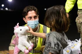 Military personnel hand out food, drink, toys, and blankets during Operation Pitting at RAF Brize Norton to arrivals who have been evacuated from Afghanistan, under the Afghan Relocation and Assistance Programme