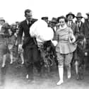 A crowd following Miss June after she had completed a parachute jump from an air balloon at Blackpool Air Pageant.  (Photo by Central Press/Getty Images)