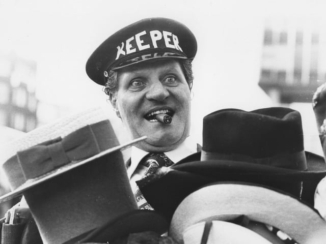 Tommy Cooper tries out some hats. Photo: Getty Images