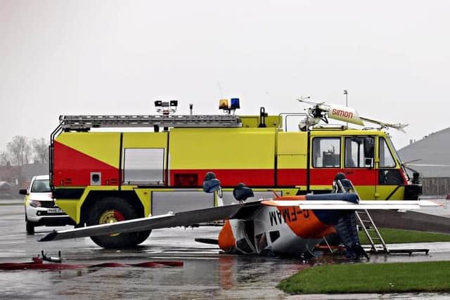 Airport emergency response crews attend to the small aircraft which reportedly blew over in strong winds on Friday (October 29). Pic credit: Paul Webster
