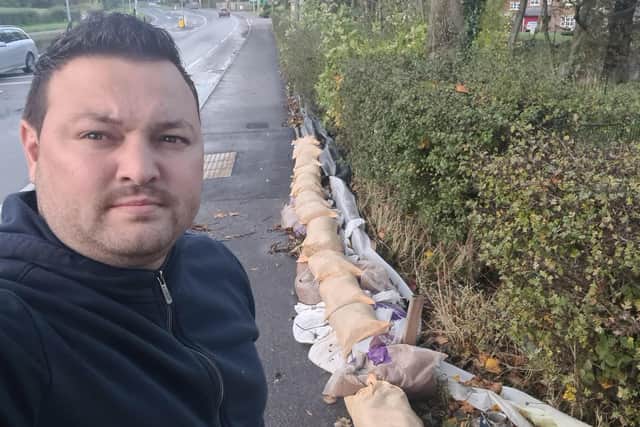 Petrica Stefanescu with  sandbags at the front of the hedge overlooking his home
