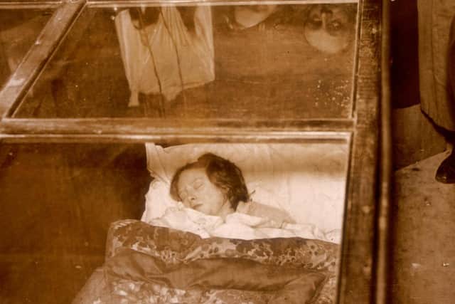 One of the starving brides of Blackpool sleeps in her glass box, watched by curious onlookers. Numerous similar public displays were recently banned. (Photo by Keystone/Getty Images)