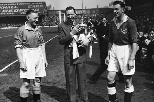 Blackpool v Portsmouth 6th May 1939. George Formby seen here at the start of the match with James Blair (left Blackpool Captain)  and Jimmy Guthrie (right Portsmouth Captain)  holding the FA Cup a week after Portsmouth beat Wolves in the final at Wembley.