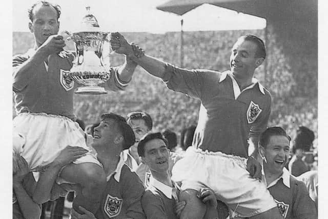Blackpool v Portsmouth 6th May 1939. George Formby seen here at the start of the match with James Blair (Left Blackpool Captain)  and Jimmy Guthrie (Right Portsmouth Captain)  holding the FA Cup a week after Portsmouth beat Wolves in the final at Wembley. Alamy Stock Photo
