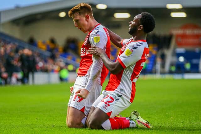 Ged Garner (left) celebrates his opening goal for Fleetwood at Wimbledon with Shayden Morris