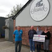 Joanne Rossall, from Kirkham, presents Rosemere Cancer Foundation’s Yvonne Stott (far right) and Blue Skies volunteer ambassador Phil Robinson (far left) with her donation watched by Peter and Harry