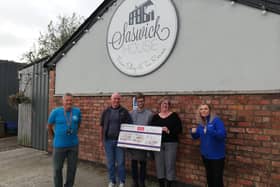 Joanne Rossall, from Kirkham, presents Rosemere Cancer Foundation’s Yvonne Stott (far right) and Blue Skies volunteer ambassador Phil Robinson (far left) with her donation watched by Peter and Harry