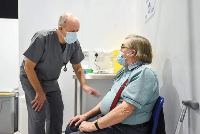 Volunteer vaccinator Stan Ralph with 87-year-old Michael Doidge.
