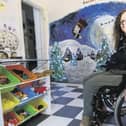 Kirsty Rea, 48, sat in her wheelchair in front of the artwork she painted by hand