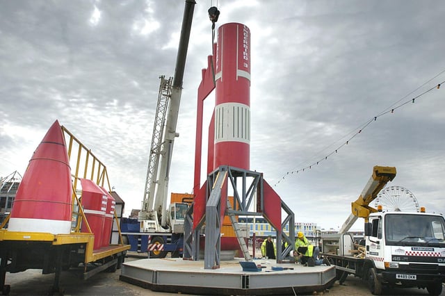 Illuminations Department workers building the model of Thunderbird 3 on Blackpool promenade. The nose cone waits to be craned into place