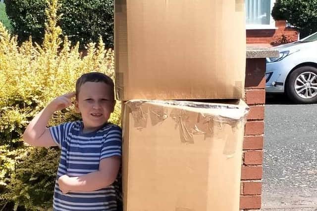 Seven-year-old Alex stood by three boxes of used crisp packets to be recycled through the Terracycle scheme