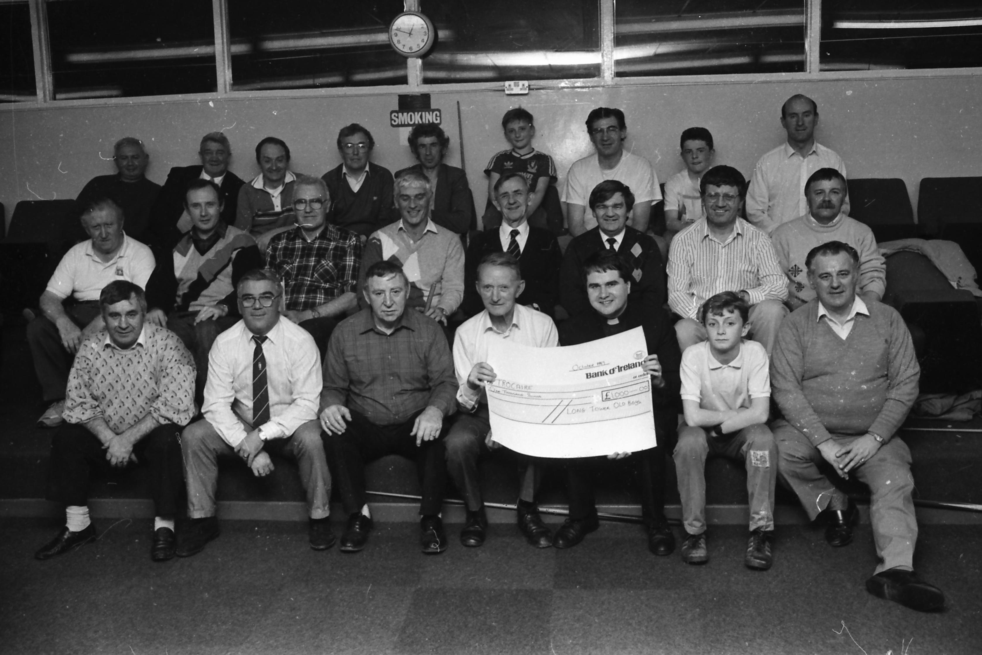 Mr. Willie Meehan, chairman of the Long Tower Old Boys’ Committee, presents a cheque of £1,000, the proceeds of a cabaret dance evening in the Delacroix lounge, to Rev. Eamon Graham, Derry Diocese representative of Trócaire. The cheque was presented at the committee’s weekly snooker session.