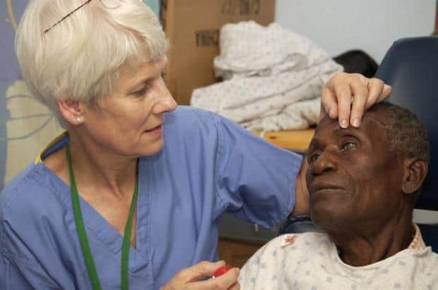 Caring Frances King tends to a patient on a Mercy Ships visit to Africa