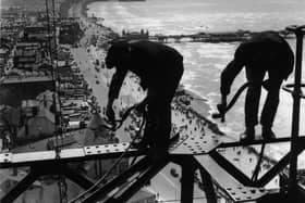 Balancing on girders high above the promenade workmen repair Blackpool Tower, 1934