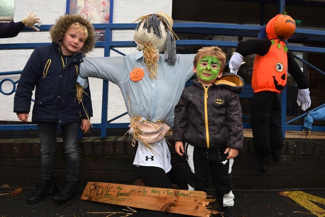 Mason Currie, five, and Archie Currie, three, pose with the scarecrows on display.
