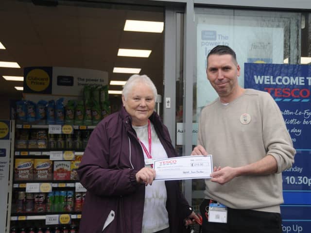 John Emery, Manager of Tesco Express, Poulton, presents a cheque for £215 to Susan Ratcliffe of Poul