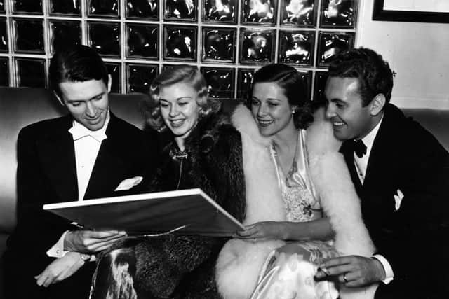Actor James Stewart, film actress and dancer Ginger Rogers and Mr and Mrs Allan Jones looking at a picture.  (Photo by General Photographic Agency/Getty Images)