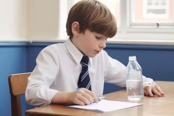 A child working at school with water on his desk.