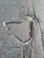 The pothole that County Cllr John Fillis was told had been filled in after he reported it - but which was still blighting the road days later