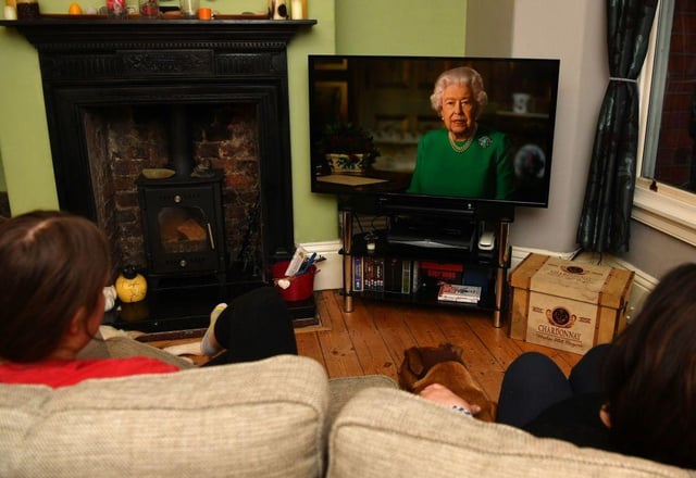 A family watching Britain's Queen Elizabeth II deliver a special address to the UK and Commonwealth recorded at Windsor Castle in relation to the coronavirus outbreak (Photo: PAUL ELLIS/AFP via Getty Images)