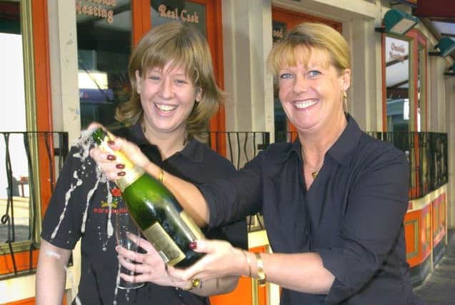 Staff at the Rose and Crown pub in Blackpool were celebrating their Best Pub trophy in the Tourism Awards, 2005
Landlady Debra Bradley (right) opens the champagne with barperson Helen Grady
