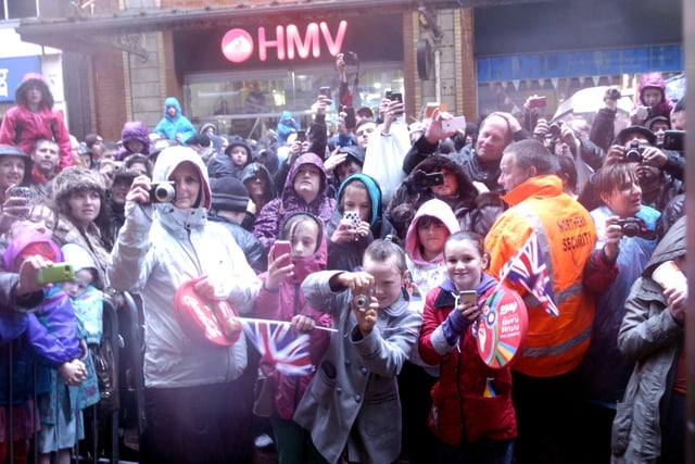 Crowds wait in the rain for a glimpse of the torch in Blackpool Town Centre