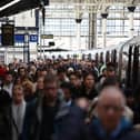 Commuters walk along a packed platform after a single train arrived during the morning rush hour, at Waterloo Station in London on April 8, 2024, as train drivers strike over pay. (Photo by HENRY NICHOLLS / AFP)