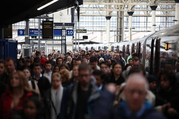 Commuters walk along a packed platform after a single train arrived during the morning rush hour, at Waterloo Station in London on April 8, 2024, as train drivers strike over pay. (Photo by HENRY NICHOLLS / AFP)