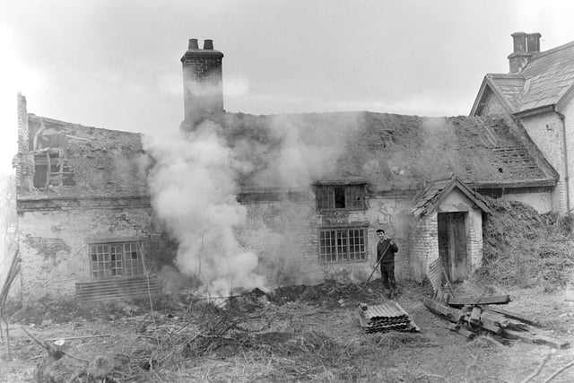The demolition of Normoss Farm, Hardhorn, in 1964. The corrugated iron roof had been removed and the old thatch beneath had been stripped off for burning