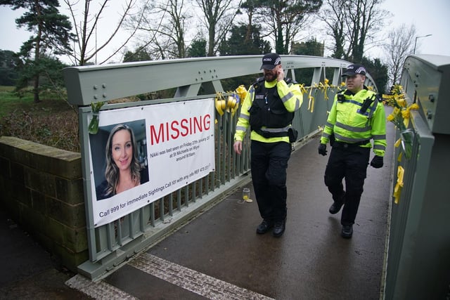 Police officers walk past a missing person appeal poster for Nicola Bulley in St Michael's. Photo: Peter Byrne/PA Wire